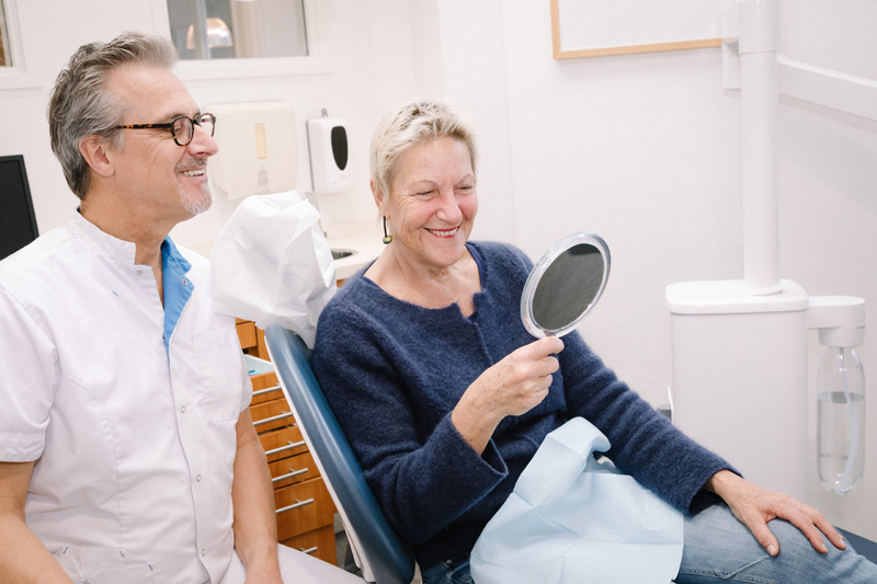 Tandarts laat een patiënt het belang van een goede mondhygiëne zien